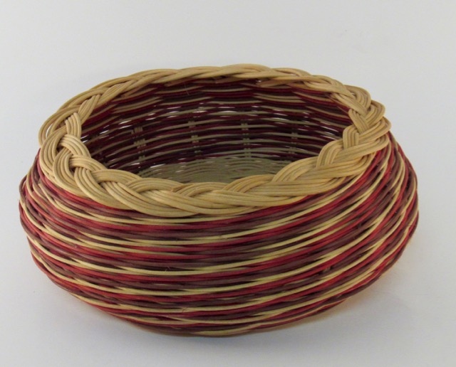 Handwoven basket featuring natural and burgundy reed
